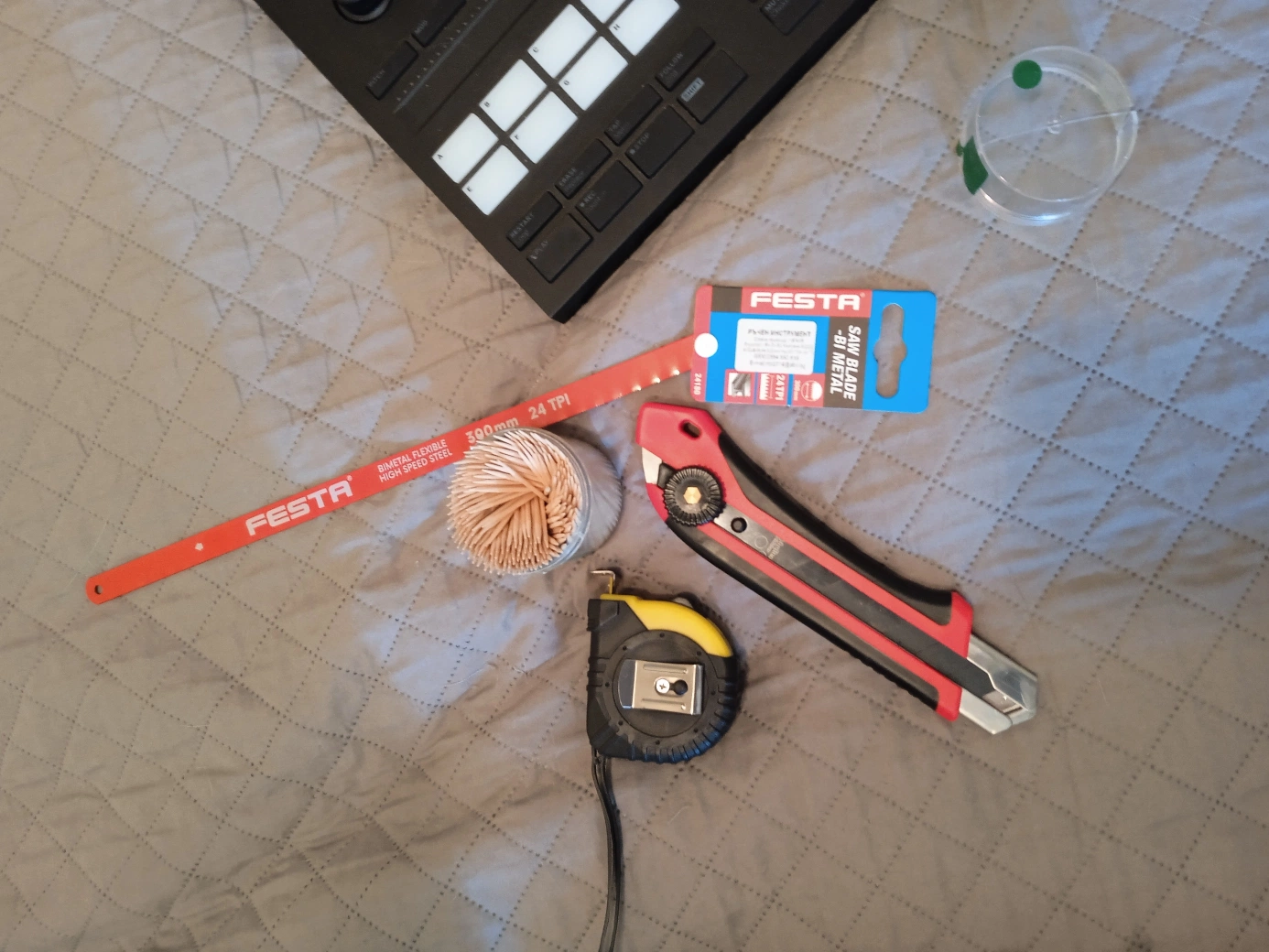 Tools laid out for DIY Maschine MK3 foam case cutting — hacksaw blade, utility knife, tape measure, toothpicks